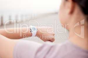 Time is precious, use it smartly. Shot of an unrecognisable woman using a smart watch during her run on the promenade.