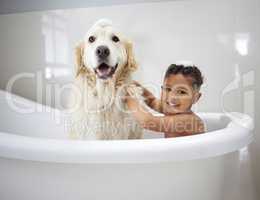 Were clean boys. Shot of an adorable little boy sitting in the bathtub with his Golden Retriever during bath time at home.