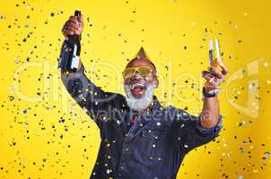 Its time to celebrate. Portrait of a cheerful senior man celebrating and drinking champagne in studio against a yellow background.