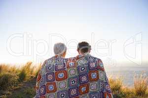 Romance on the hillside. View of a senior couple sitting on a hillside together.