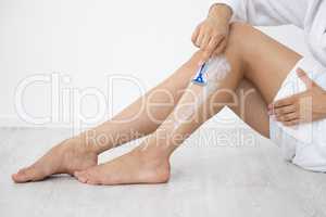 Shaving my legs is a weekly ritual. Cropped shot of an unrecognizable woman sitting down and shaving her legs at home.