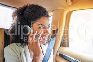 Im pulling up to the office as we speak. Shot of an attractive young businesswoman making a phonecall while being driven to work on her morning commute.