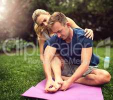 I might have pinched a nerve. Shot of a young man suffering from a foot injury while working out with his girlfriend outdoors.