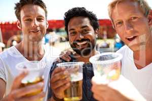 Beer buddies bonding. Three young men toasting their beers at a music festival.