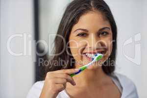 Fresh breath requires daily maintenance. Shot of an attractive young woman getting ready in her bathroom.