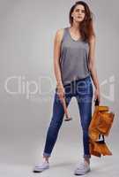 I can fix anything. Full length studio portrait of casually-dressed young woman holding a hammer and tool belt.