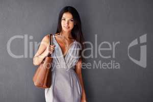 Ive got everything I need in my handbag. Studio portrait of an attractive young woman holding her handbag.