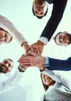 Staying motivated in their quest for success. Low angle shot of a diverse group of businesspeople joining their hands together in unity.