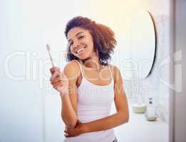 The surest way to have a sparkly day. Shot of an attractive young woman brushing her teeth in the bathroom at home.