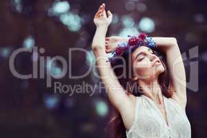 We belong where we feel free. Shot of a beautiful young woman wearing a floral head wreath outdoors.