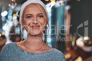 Im getting in touch with the christmas spirit. Portrait of a cheerful young woman wearing a festive hat at home during christmas time.