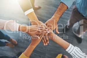 We each have a collective role to play. Closeup shot of an unrecognizable group of businesspeople joining their hands together in a huddle.