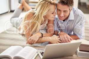 Theyre one thorough couple. Shot of a mature couple lying on their living room floor doing some online research.