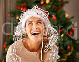 Its snowing. Shot of a beautiful young woman enjoying a playful moment with Christmas decorations.