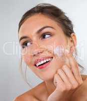 Moisturizing is important. Cropped studio shot of a beautiful young woman applying cream to her face.