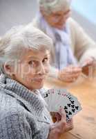 Helping the time pass with card games. Shot of senior citizens playing cards together.