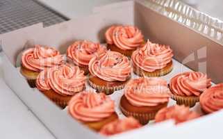These are ready to be delivered. Cropped shot of cupcakes in a takeaway box.