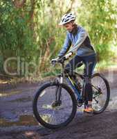 On a mission. Shot of a female mountain biker out for an early morning ride.
