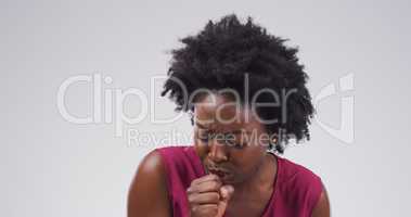 Shes gonna need a few days off. Studio shot of an attractive young woman coughing against a grey background.