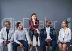 Originality will make you stand out for the interview. Studio shot of a group of corporate businesspeople waiting in line against a gray background.