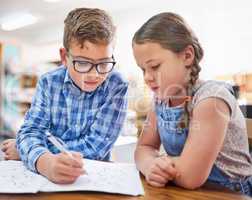 Working hard to get the best grades. Shot of two young children working together at school.