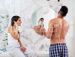 Freshening up for the day ahead. Shot of a young couple going through their morning routine together at home.