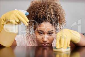 Cleaning a counter takes a lot of focus. Shot of a young woman cleaning a countertop at home.