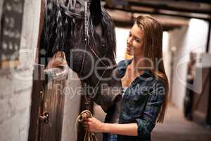 Hey girl, why. A young woman in a stable with her horse.