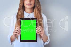 Shes standing behind her comments. Shot of an unrecognizable woman holding a digital tablet against a blue background.