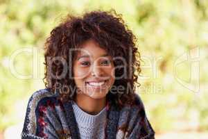 Nothing keeps this girl down. A radiant young black woman smiling broadly at the camera.