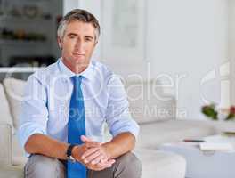 I have a lot of business experience to share. Portrait of a mature businessman sitting on a sofa.