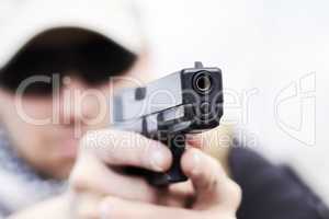 Training is hand eye coordination. Closeup selective focus of a handgun held by a soldier during a training.