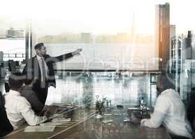 Projecting profits. Multiple exposure shot of businesspeople in a meeting superimposed on a cityscape.