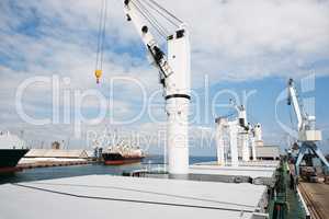 The shipyard never sleeps. A photo of a harbor with anchored ships with cranes.