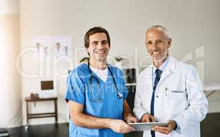 We use cutting edge technology at our practice. Portrait of two medical practitioners using a digital tablet in a hospital.