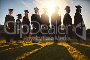 Let new adventures begin. Shot of a group of university students standing together on graduation day.