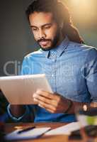 Be persistent in your search for success. Cropped shot of a young designer working late on a digital tablet in an office.