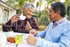 The epitome of a relaxing retirement. Shot of a happy older couple having tea together outdoors.