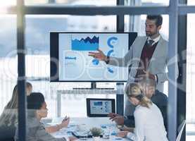 A goal without a plan is just a wish. Shot of a businessman discussing charts on a monitor to businesspeople in the boardroom.