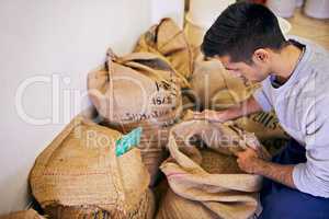 Preparing for the long export journey. Shot of a man looking at raw coffee beans.
