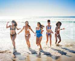 When the weathers warm, spend it in the water. Shot of a group of happy young women having fun together at the beach.