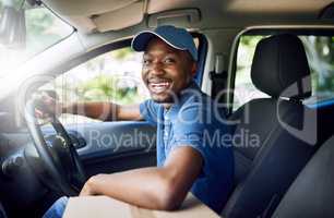 Im on my way. Portrait of a young postal working sitting in his car during a delivery.