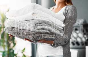 Mission accomplished, fresh and clean towels. Cropped shot of an unrecognizable young woman doing her laundry at home.