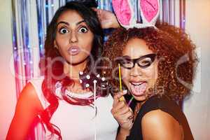 We might forget, but the camera will remember. Shot of two beautiful young women having fun with props in a photobooth.