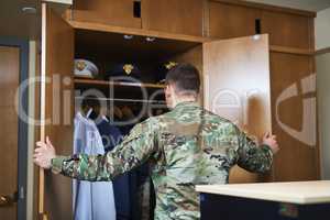 Discipline is a choice made daily. Shot of a young soldier standing getting dressed in the dorms of a military academy.