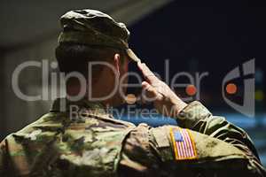 Loyal is the soldier who loves his country. Rearview shot of a young soldier standing at a military academy and saluting.