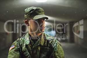 Stay alert, stay alive. Shot of a young soldier standing outside on a cold night at a military academy.