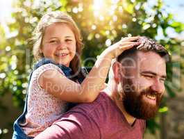 Making her girlhood a happy one. Shot of an adorable little girl enjoying a piggyback ride from her father in their backyard.