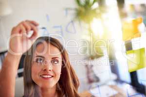 She makes mind maps work for her. Shot of an inspired young businesswoman laying out a business plan with adhesive notes against a glass wall.