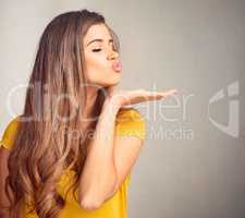 I have nothing but love for you. Closeup of an expressive young woman against a grey background.